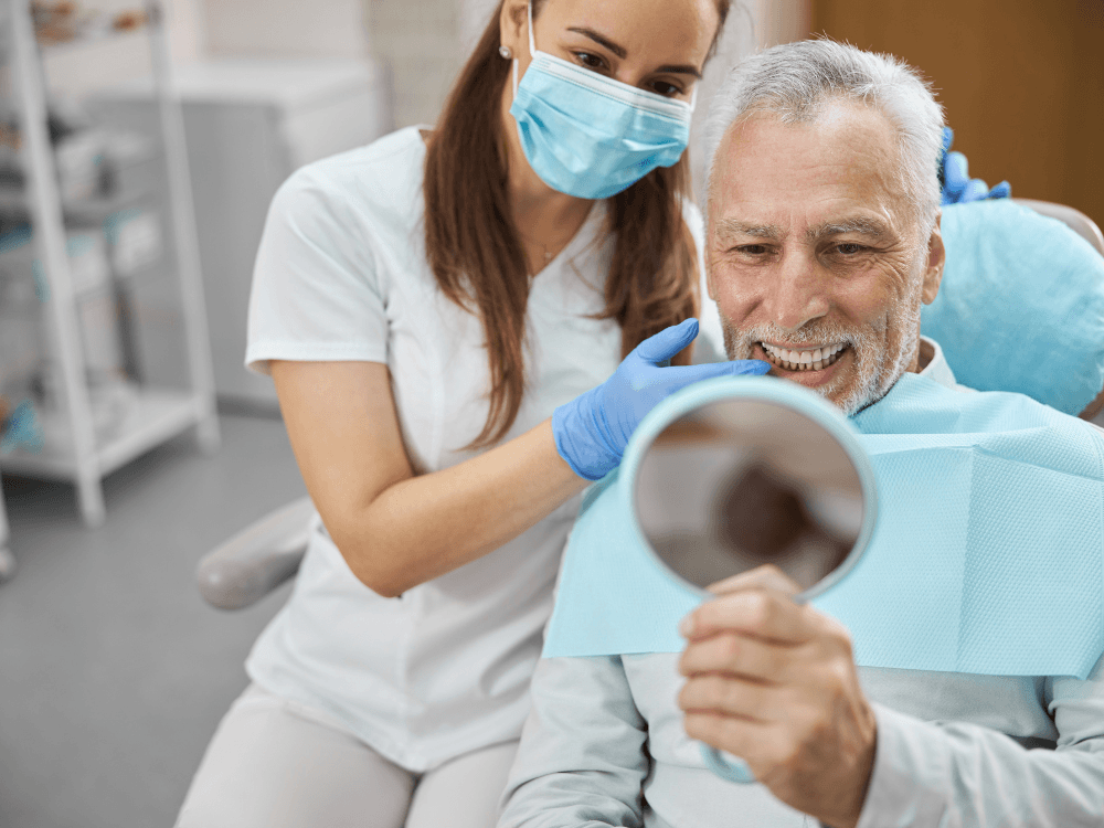 Paciente sorri ao conferir o resultado do implante dentário sem parafusos durante consulta de acompanhamento em clínica odontológica.