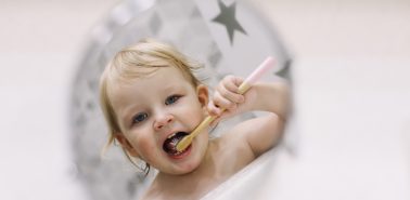 little funny girl brushing her teeth in the bathroom